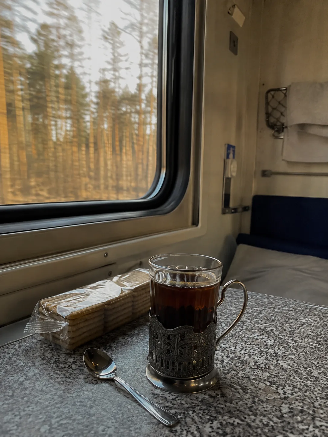 vaso de té en portavasos metálico sobre la mesa de un compartimento ferroviario ruso