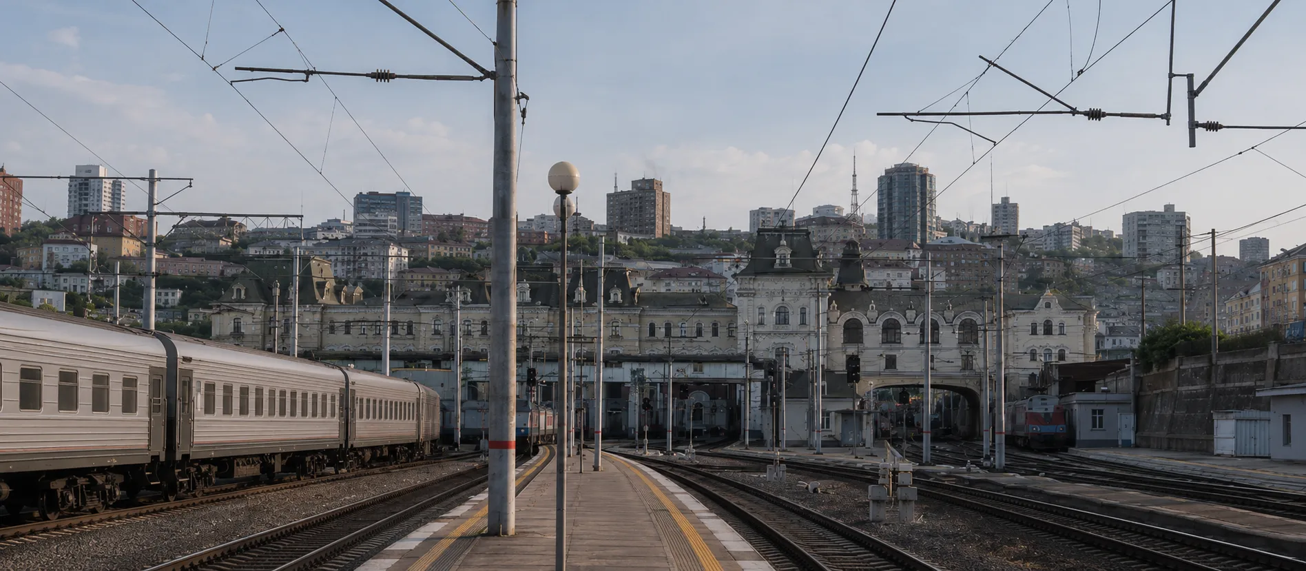 vías y andenes de la estación de Vladivostok con la ciudad real al fondo