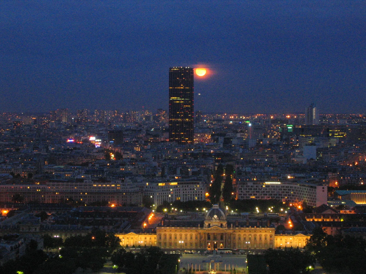 Luna junto a la torre Montparnasse sobre París al anochecer