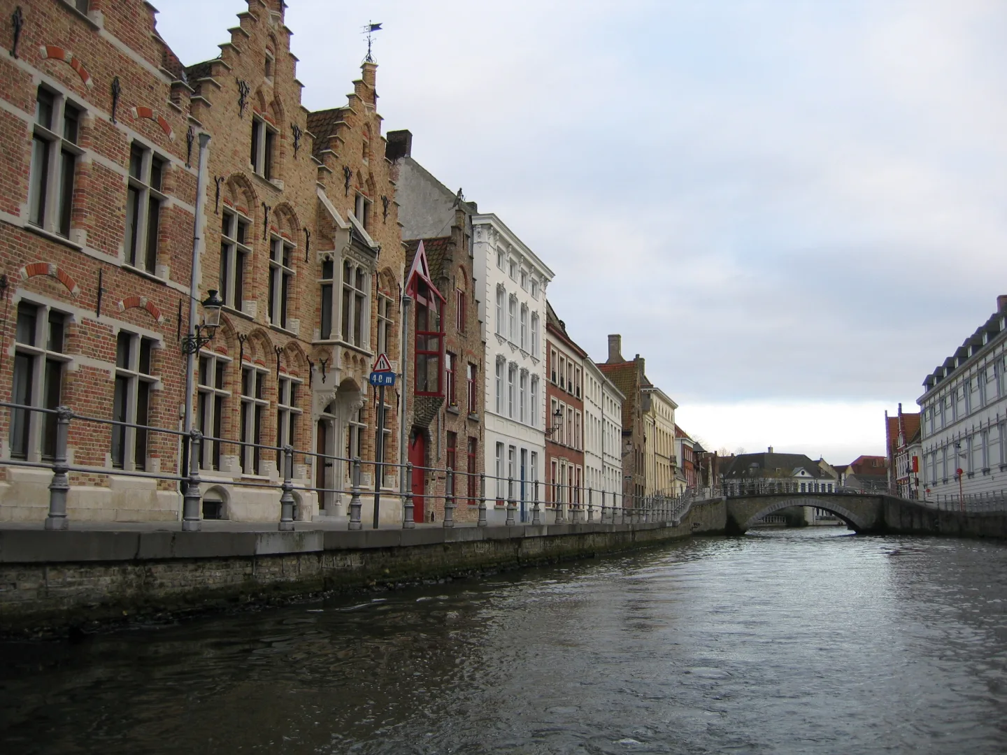 Casas de ladrillo y un puente de piedra junto a un canal de Brujas