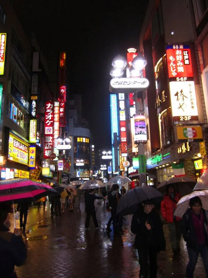 Shibuya Center-gai iluminada bajo la lluvia por la noche