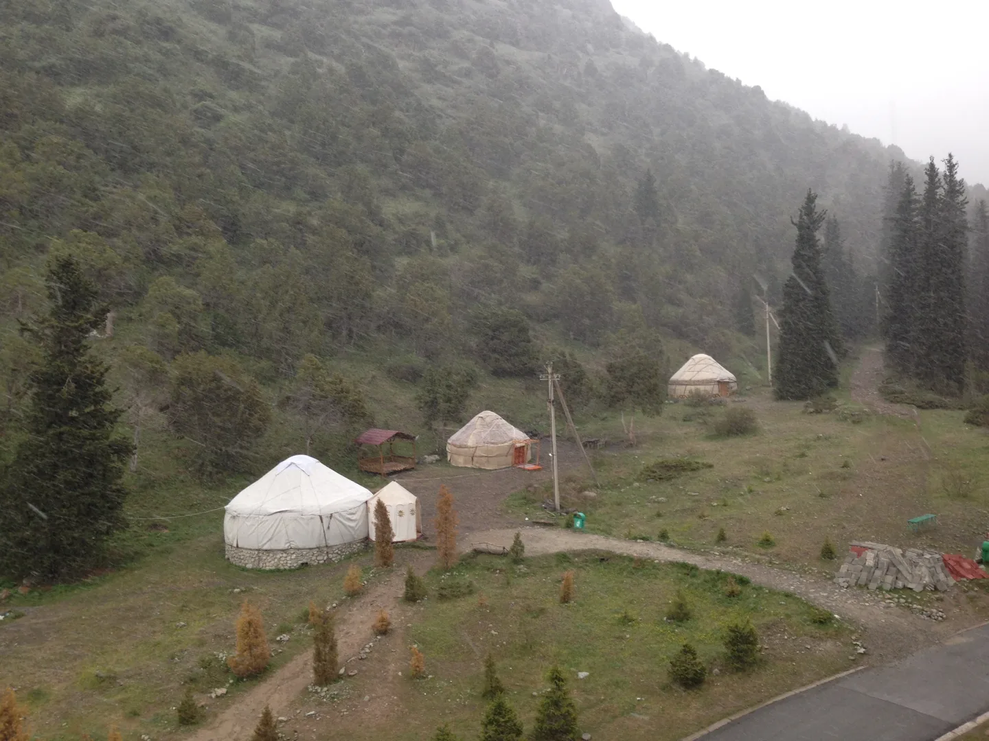 Yurtas en un valle boscoso de Kirguistán durante una nevada