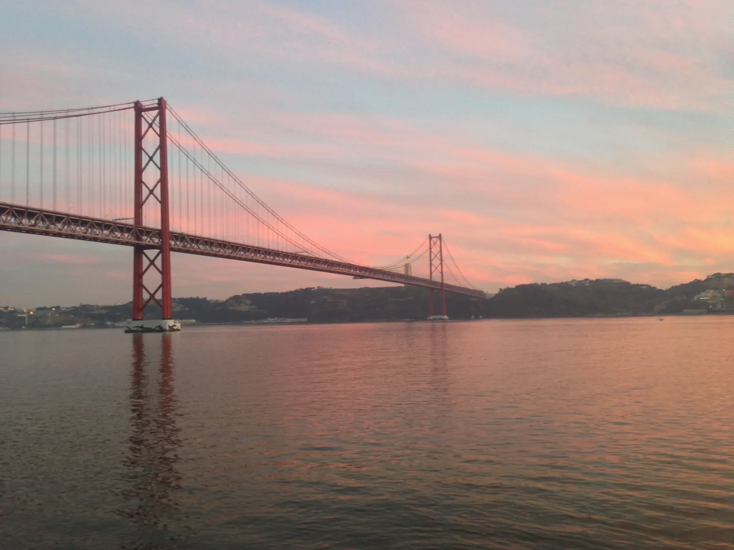 Puente 25 de Abril sobre el Tajo al atardecer en Lisboa